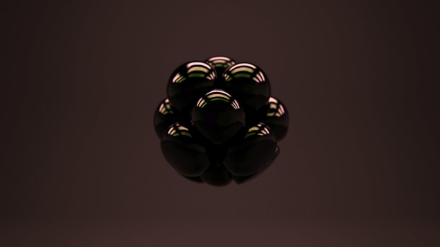 Image of a group of dark spheres balled together against a dark background