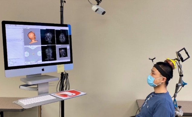 Graduate student Lu Xu wears a device that targets focused ultrasound to precise spots in the brain