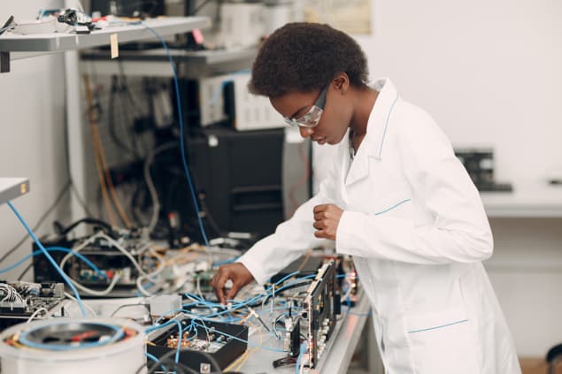 Black scientist working at an electronics bench